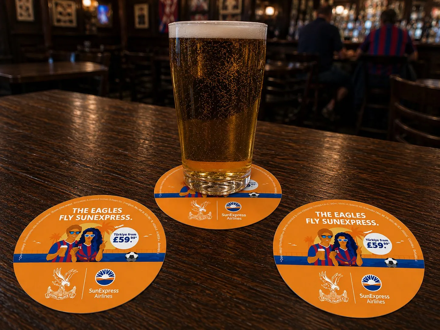Round SunExpress and Crystal Palace 'The Eagles fly SunExpress' beer mats with a pint on a pub bar