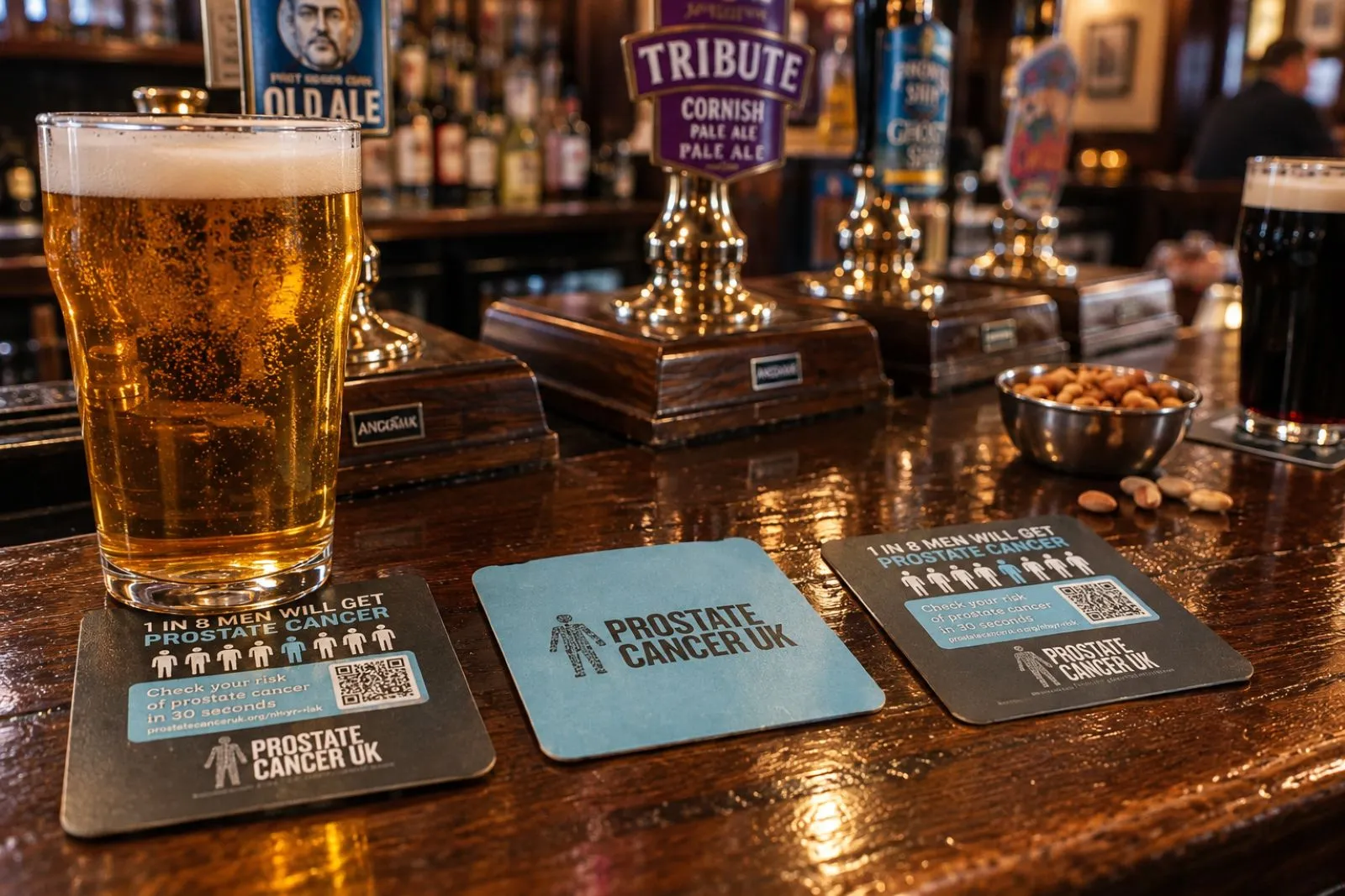 Prostate Cancer UK '1 in 8 men' beer mats beside a pint on a pub bar