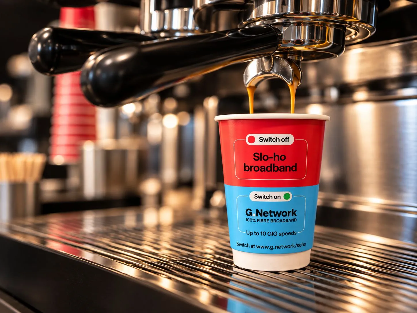 G.Network-branded coffee cup being filled under an espresso machine in a café