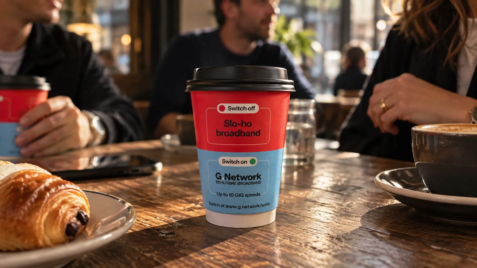 G.Network-branded takeaway coffee cup advertising 10 Gig broadband on a café table