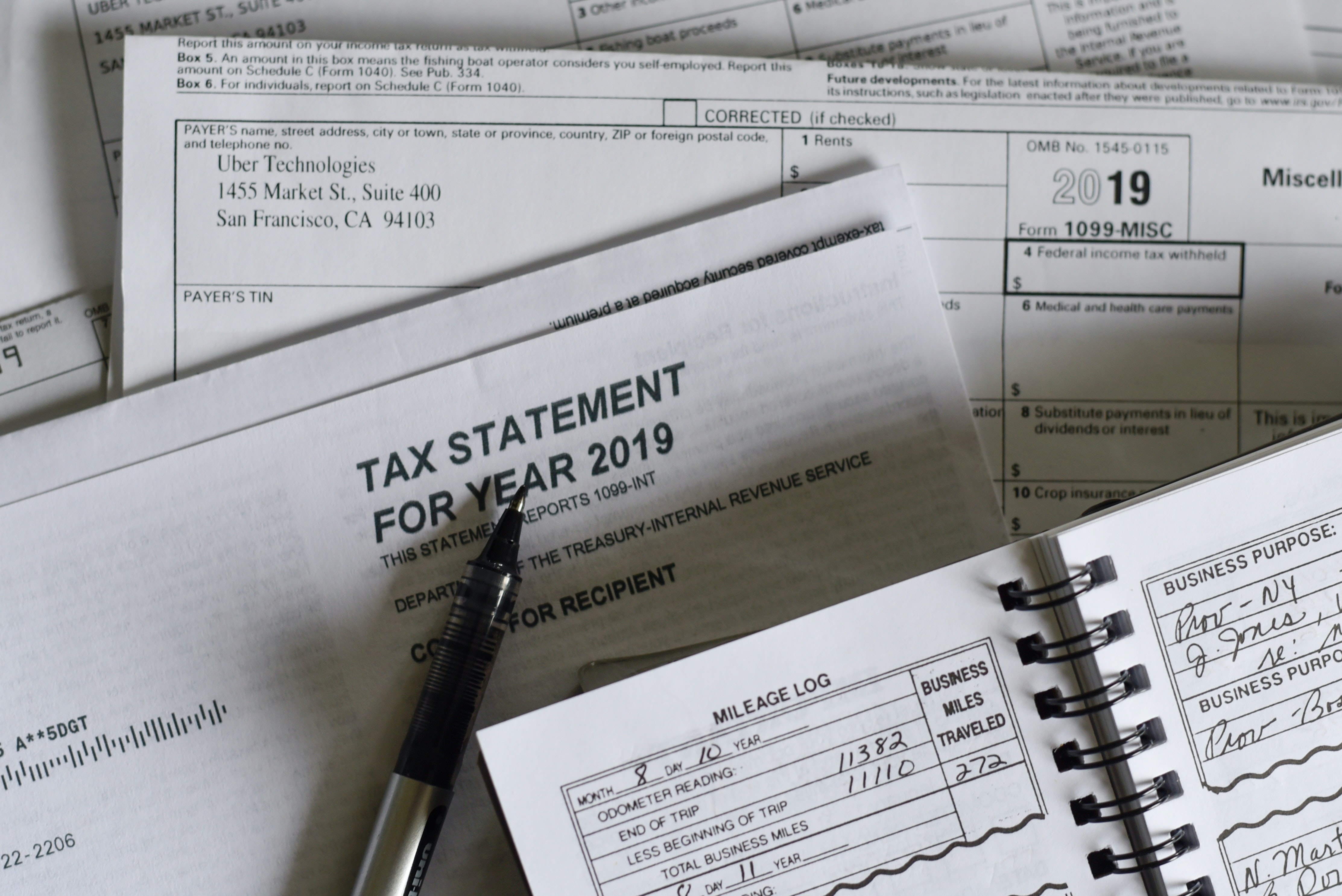 Picture of IRS form 1099 on white paper with black ink and a black and silver pen.
