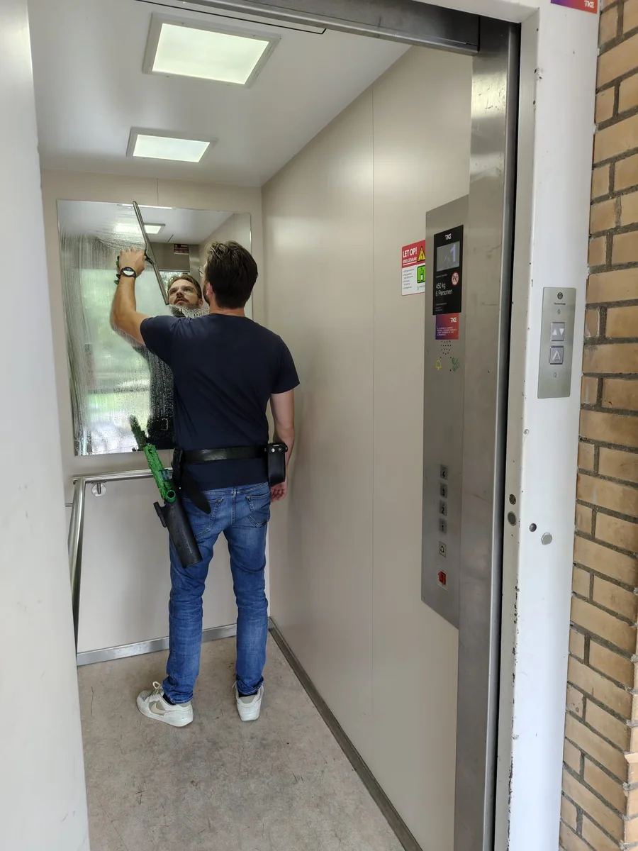 Reiniging van de liftspiegel bij VvE Jacoba van Beierenstraat in Vlaardingen.