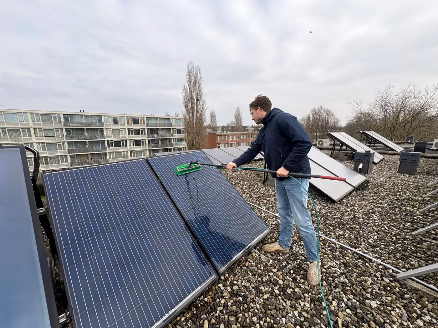 Van Klaveren reinigt zonnepanelen op een plat dak.