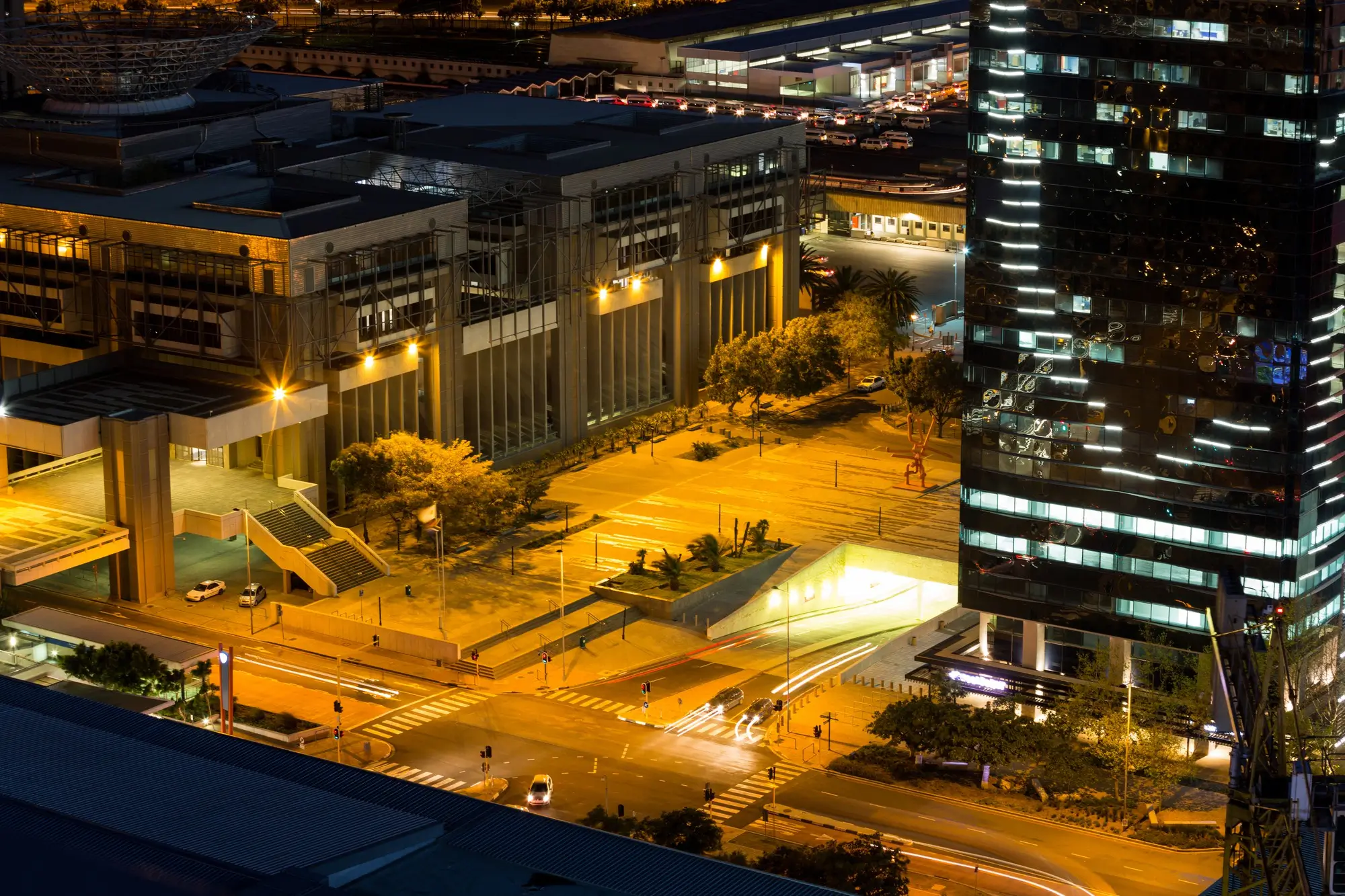 Aerial view of lit office buildings in a city district at dusk