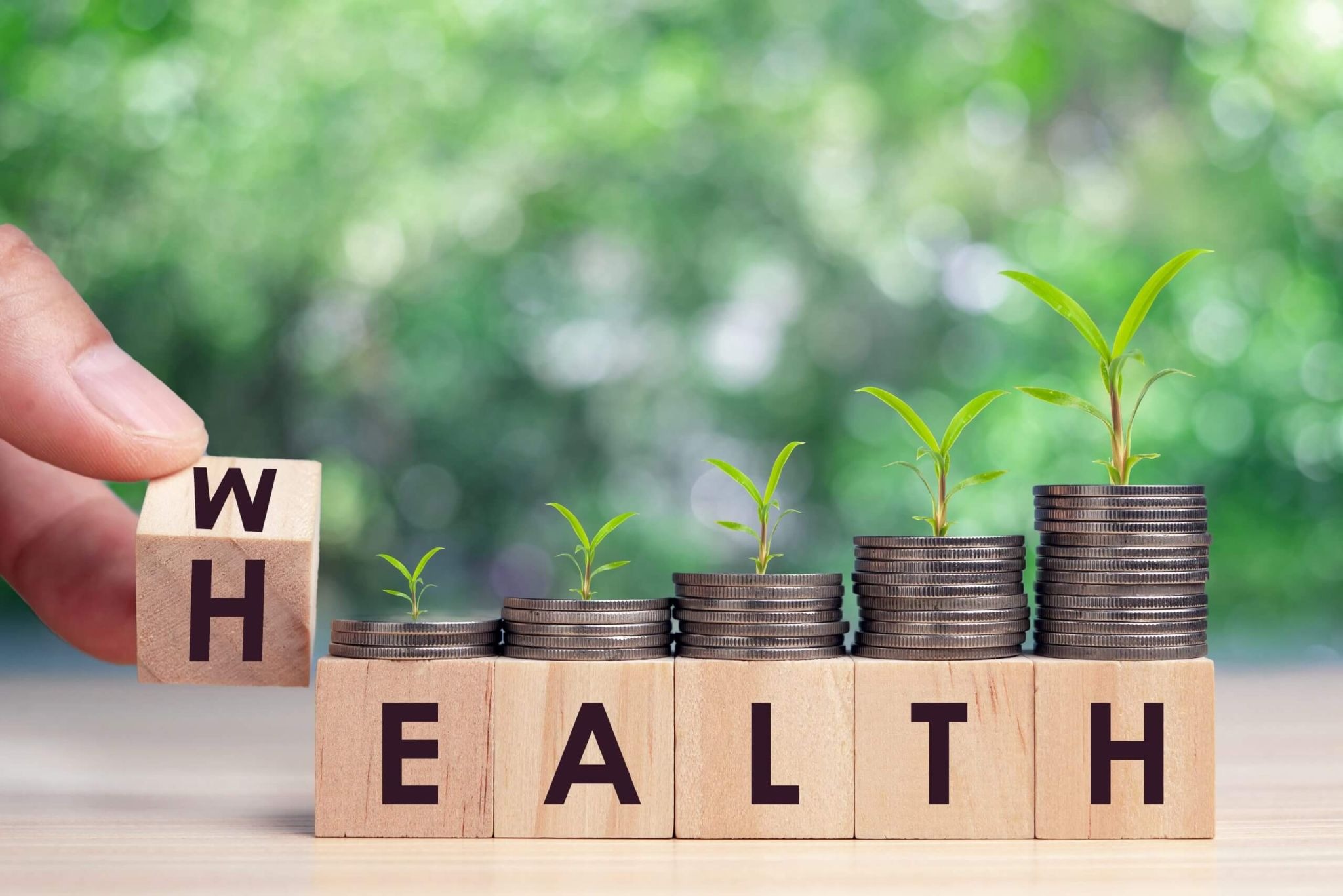 Wood building blocks with a stack of quarters on top spelling out health.
