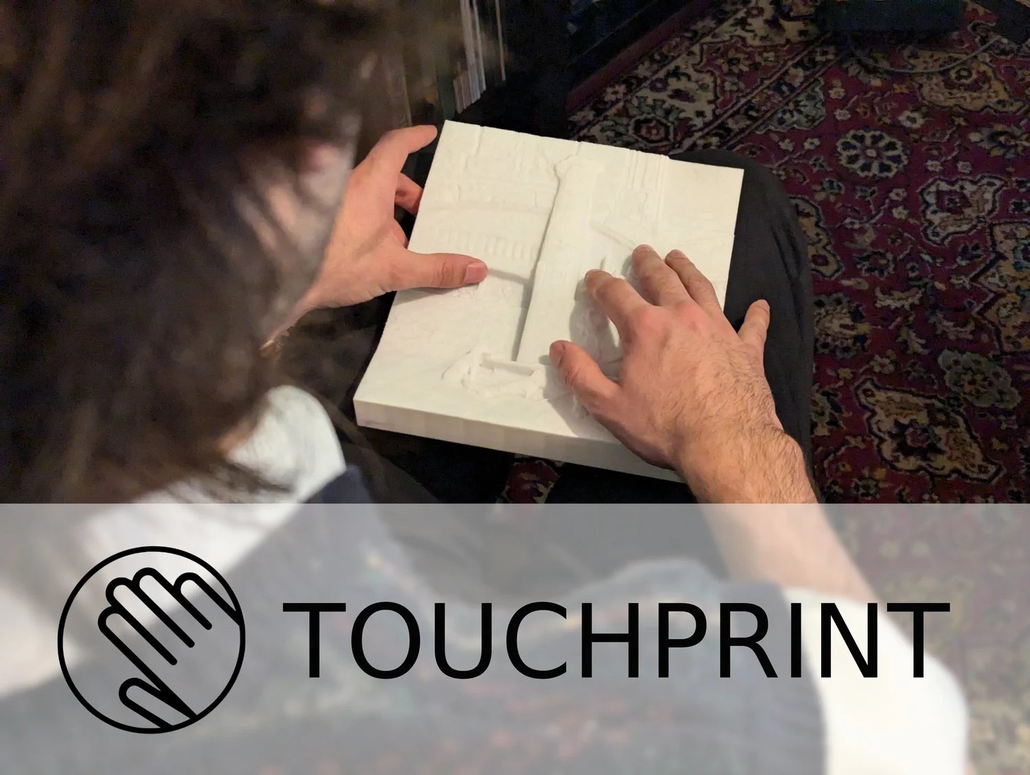 Hands exploring a tactile Touchprint relief