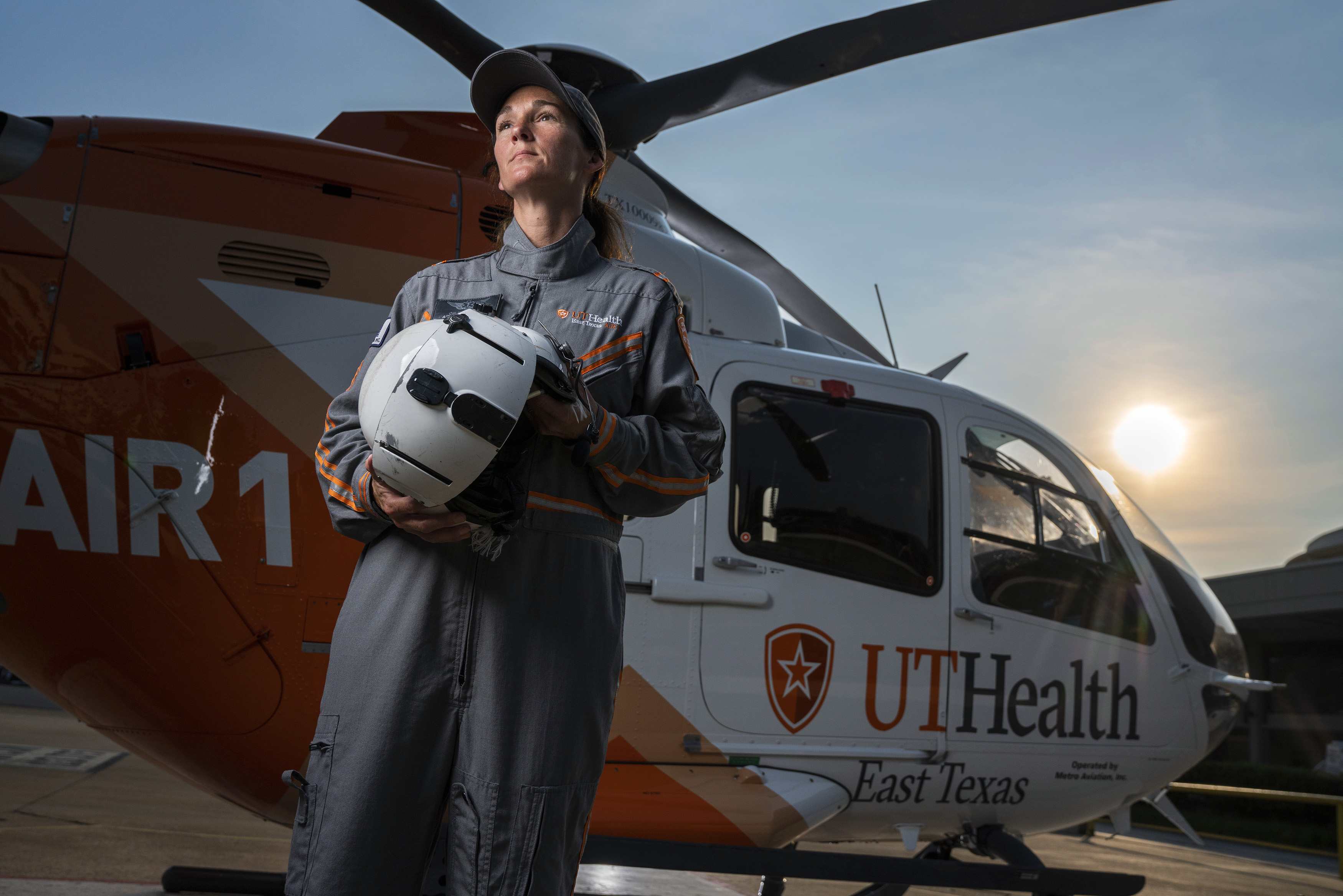 Helicopter crew member standing in front of an air ambulance helicopter