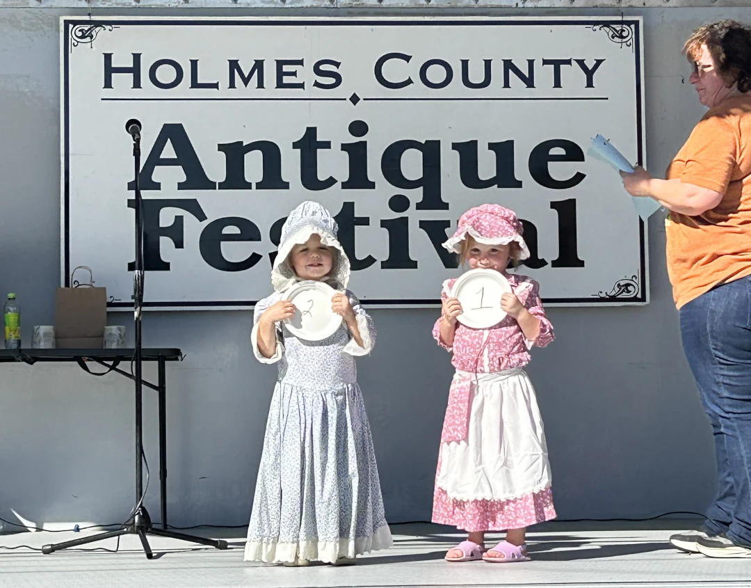 two children in outfits holding up numbers