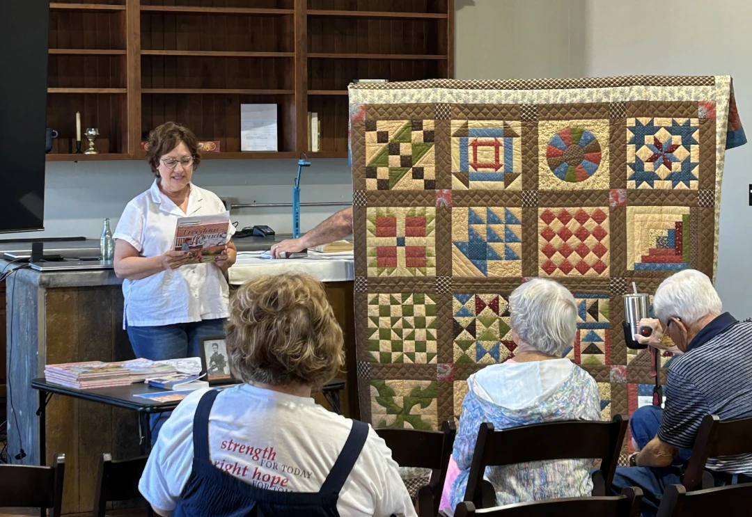 small group listening to details about a quilt