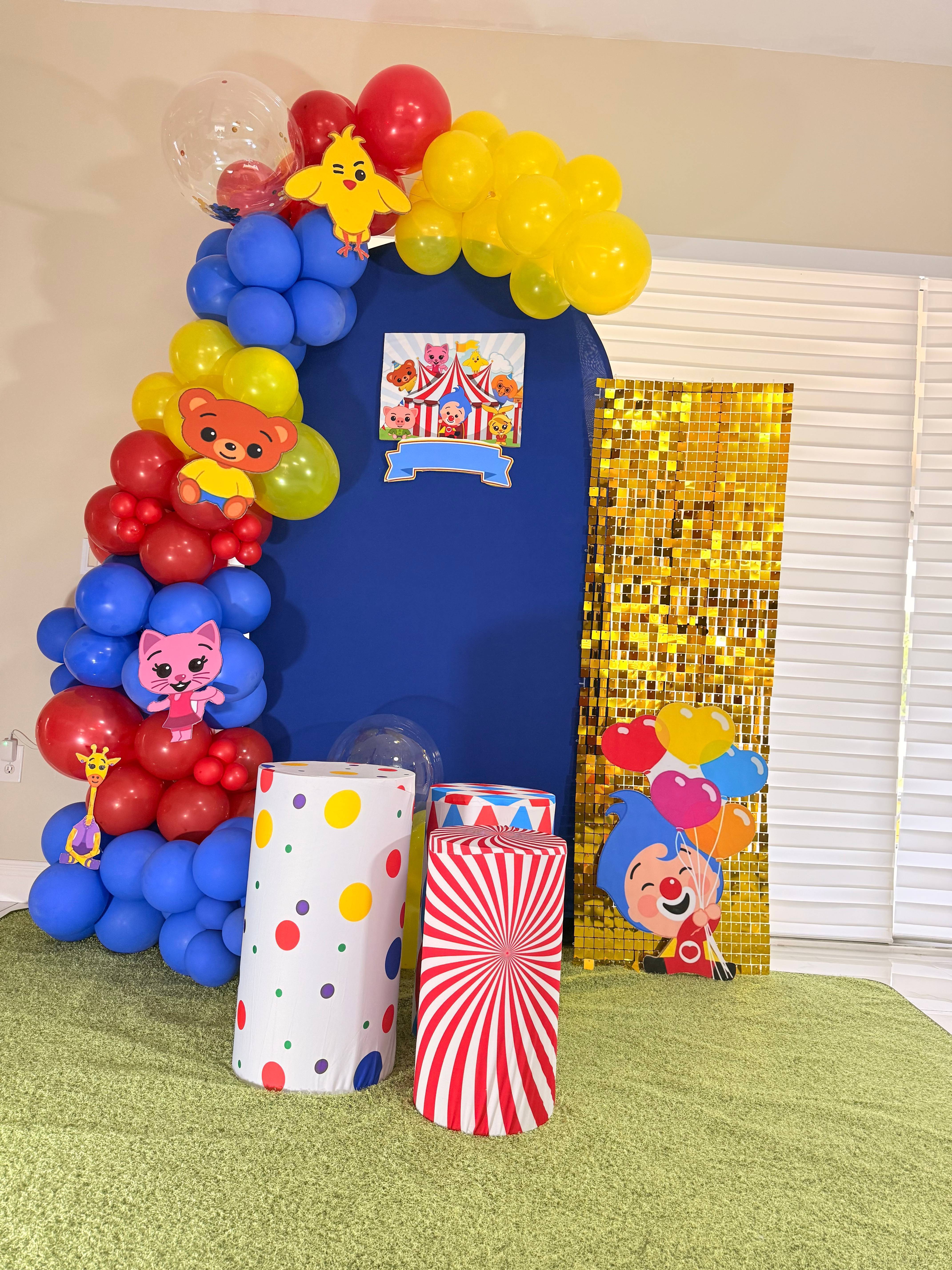 Circus-themed party display with colorful balloons, animal cutouts and pedestals.