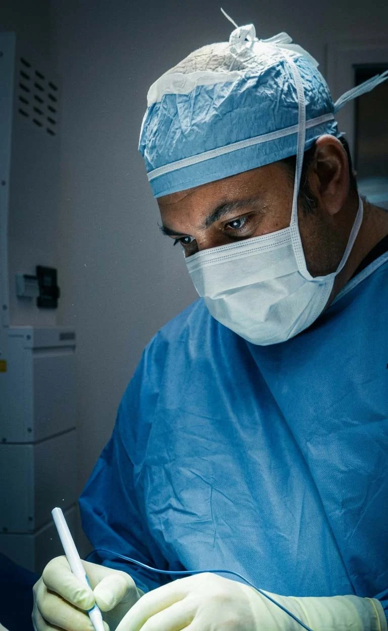 Darren M. Smith, MD, FACS wearing a surgical cap, mask, and gown during a procedure.
