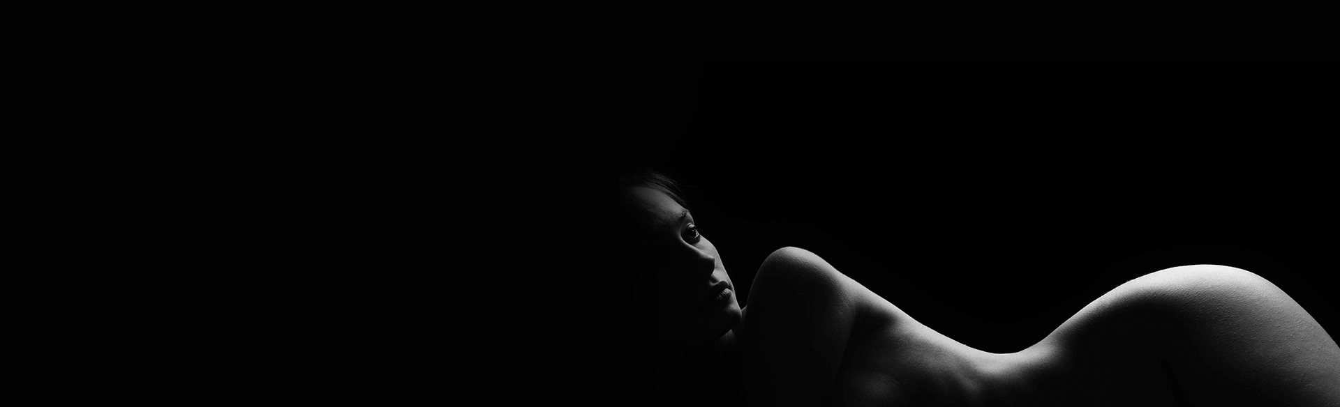 Black-and-white silhouette of a reclining woman in side profile