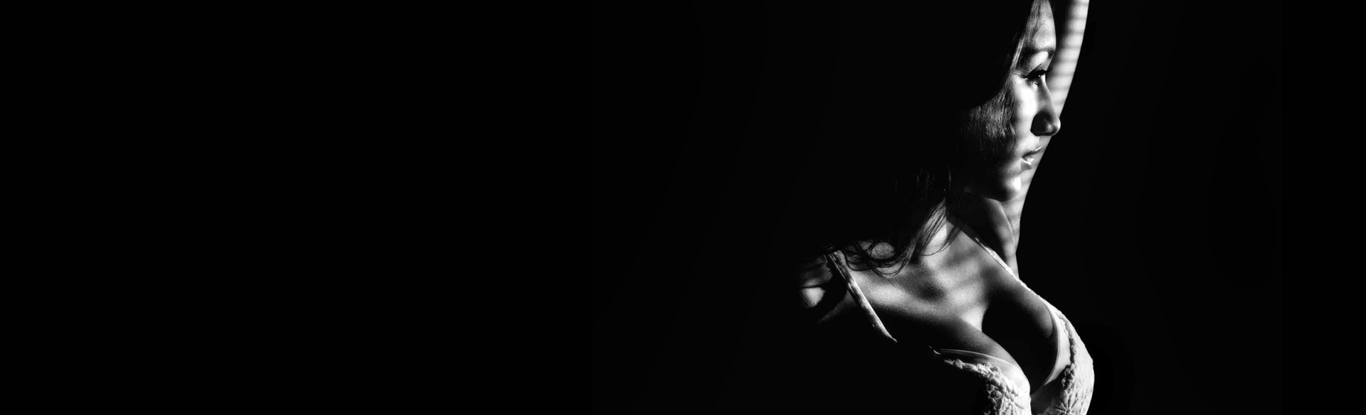 Black-and-white profile of a woman wearing a bra
