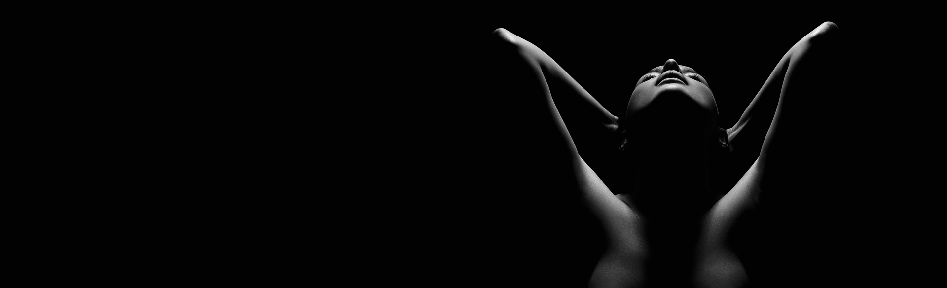 Black-and-white silhouette of a woman with her arms raised