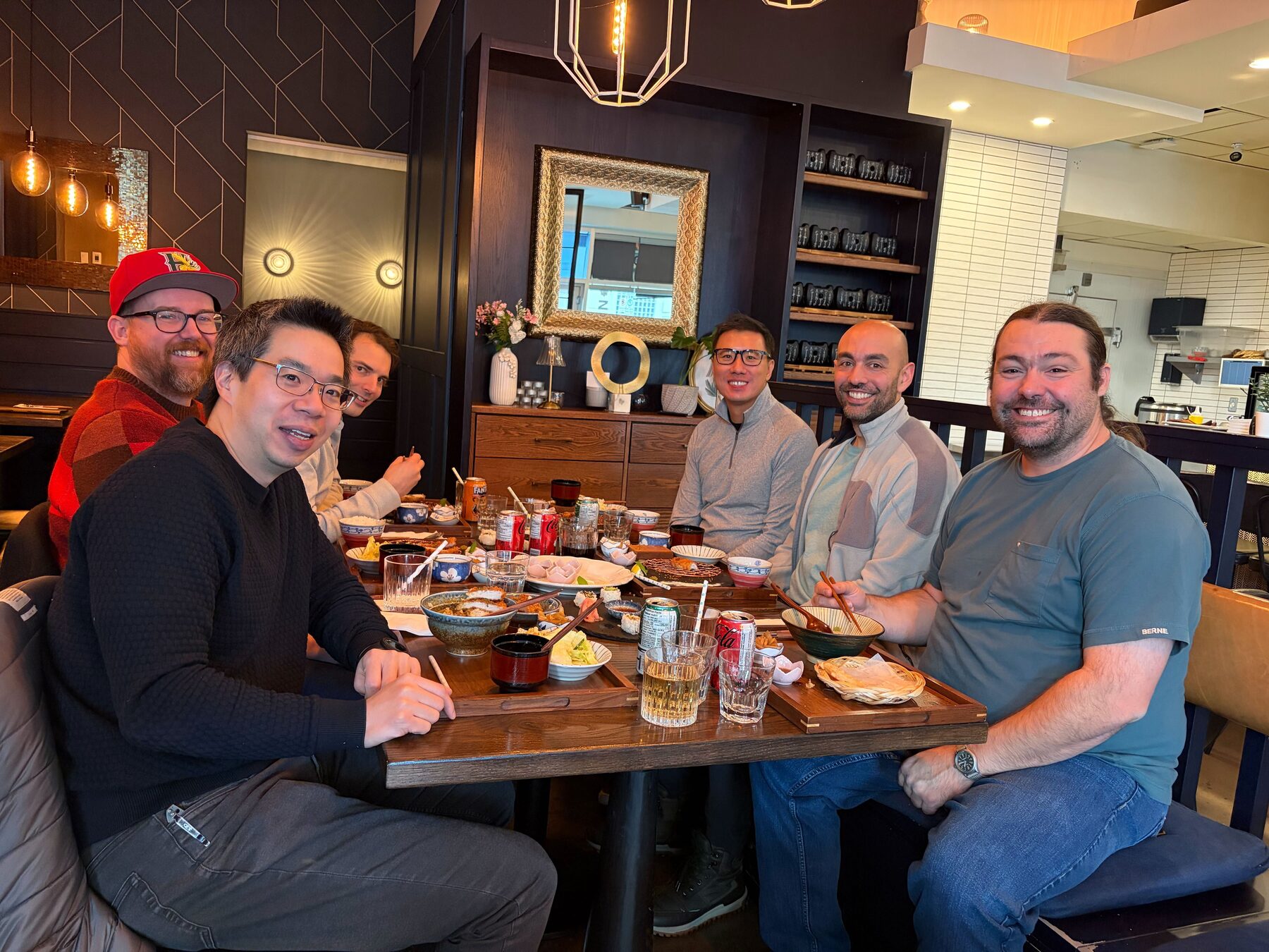 Imply team members at a restaurant table during a group meal