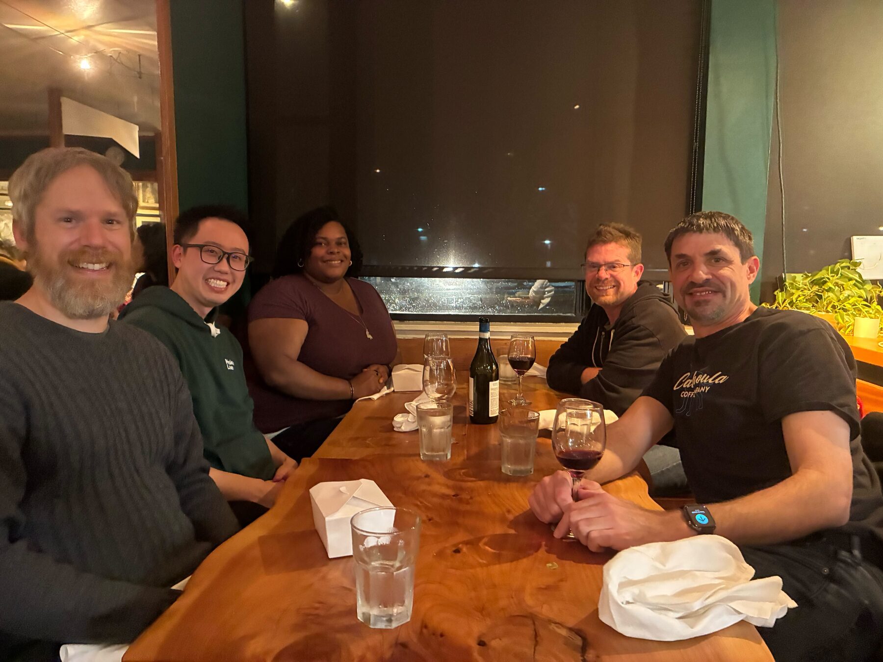 Imply team members sharing wine and dinner at a restaurant