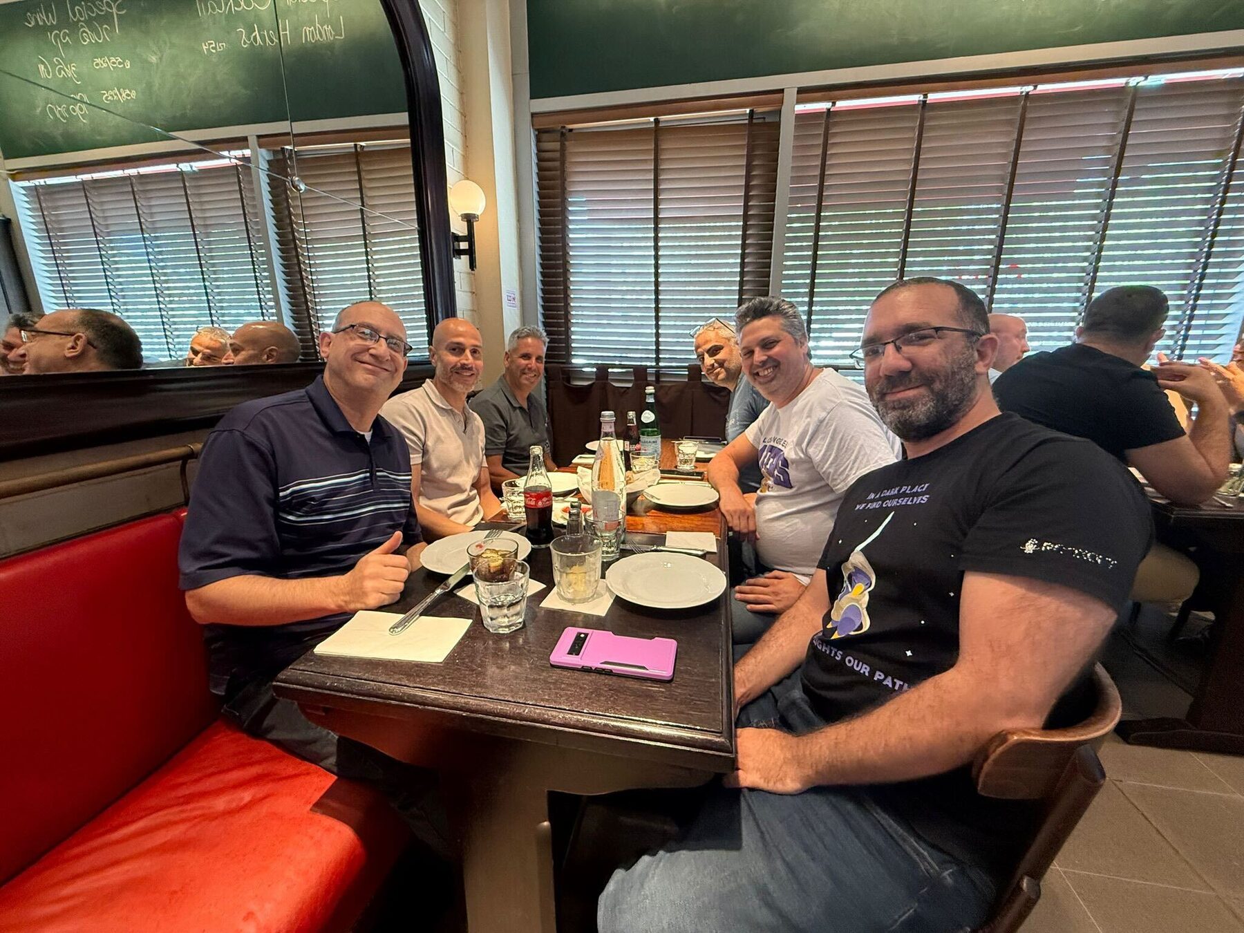 Six Imply team members sharing a meal at a restaurant