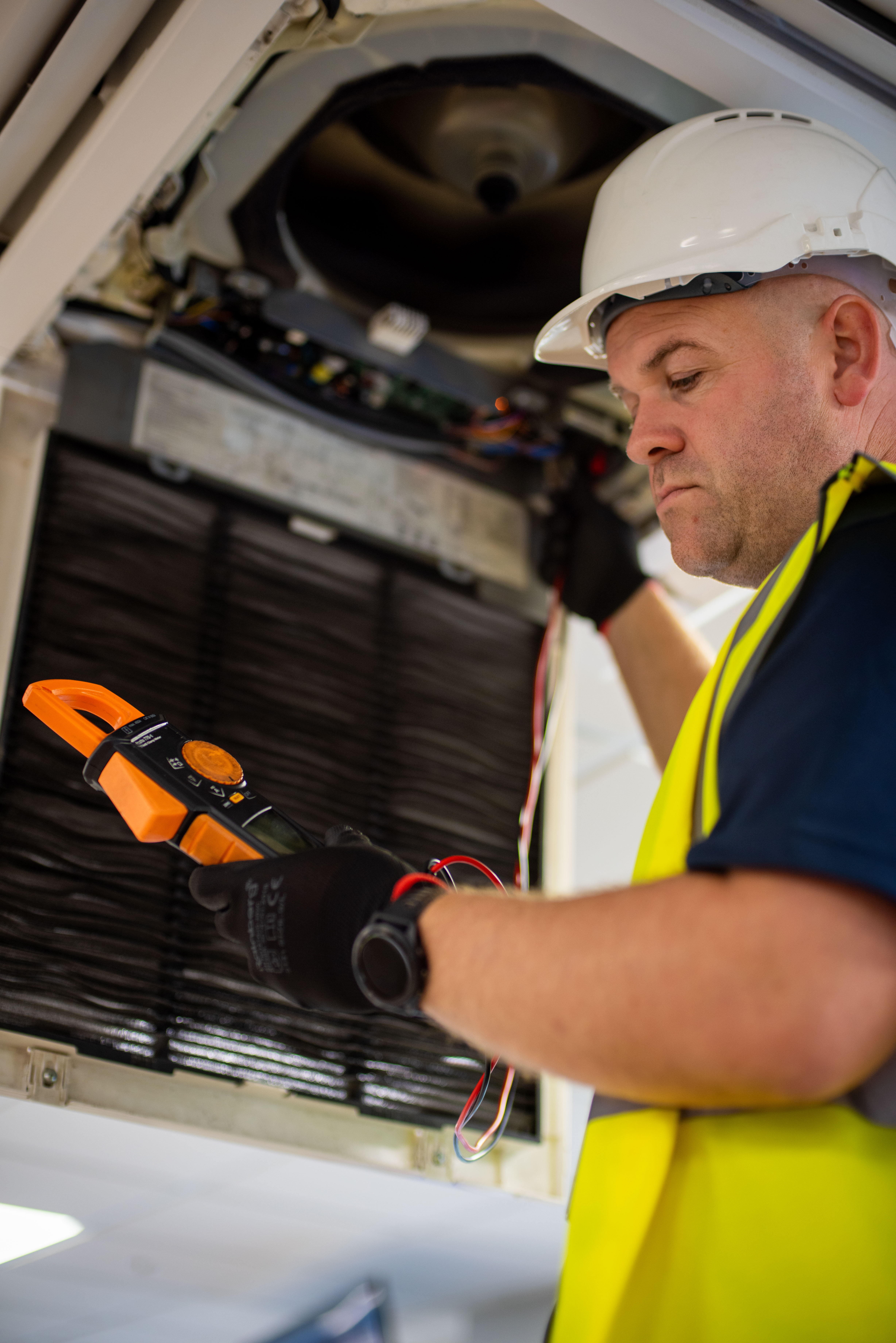 Emtec engineer servicing a fan coil unit at a school site