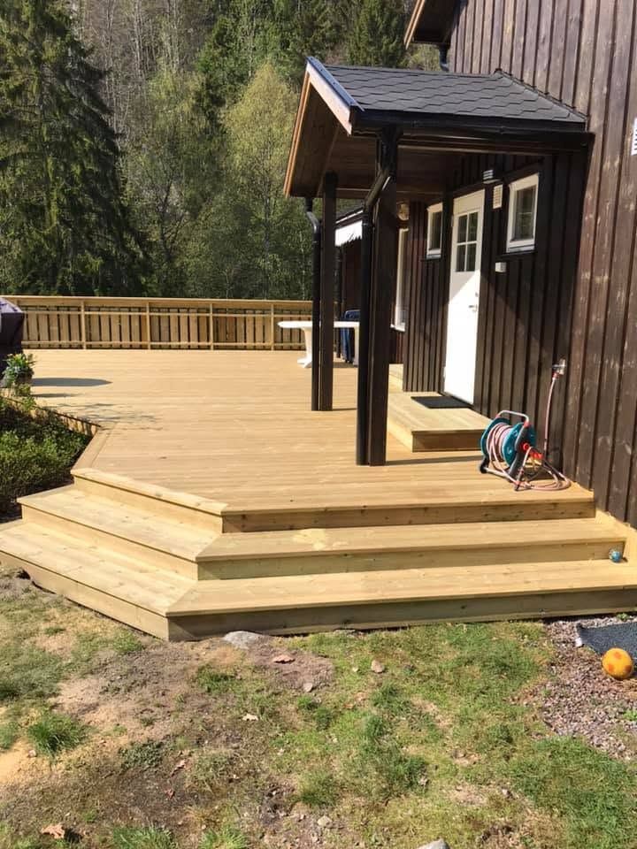 Ny terrasse i tre med brede trapper og overbygd inngang