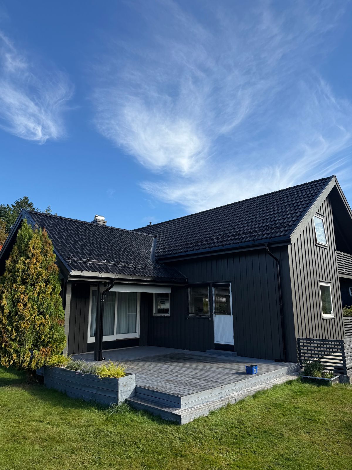 Hus med nylagt sort tak og ny terrasse