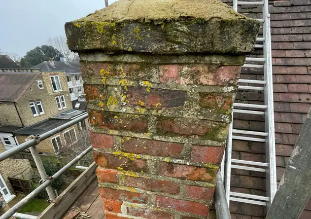 Worn brick chimney stack needing repair and restoration