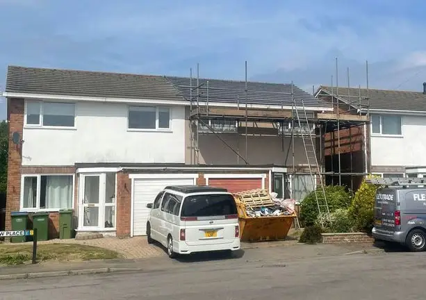 Residential property undergoing structural roof repair with scaffolding