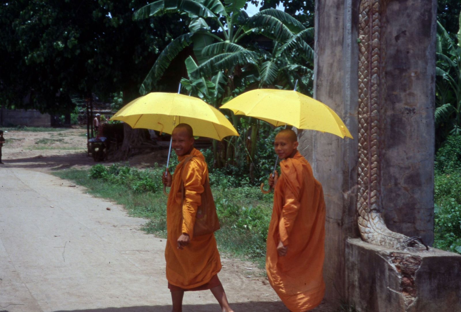 Monks, yellow umbrellas against the sun