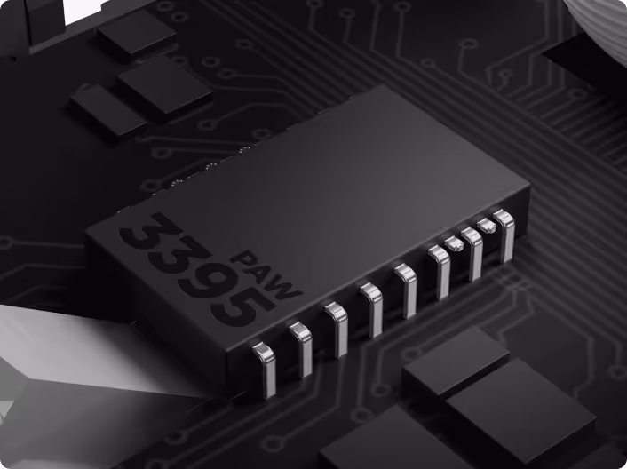 Close-up of a black electronic microchip labeled PAW 3395 mounted on a circuit board.