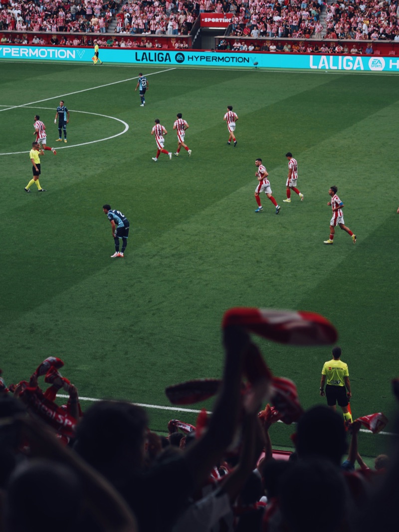 Football match in a packed stadium, seen from the stands