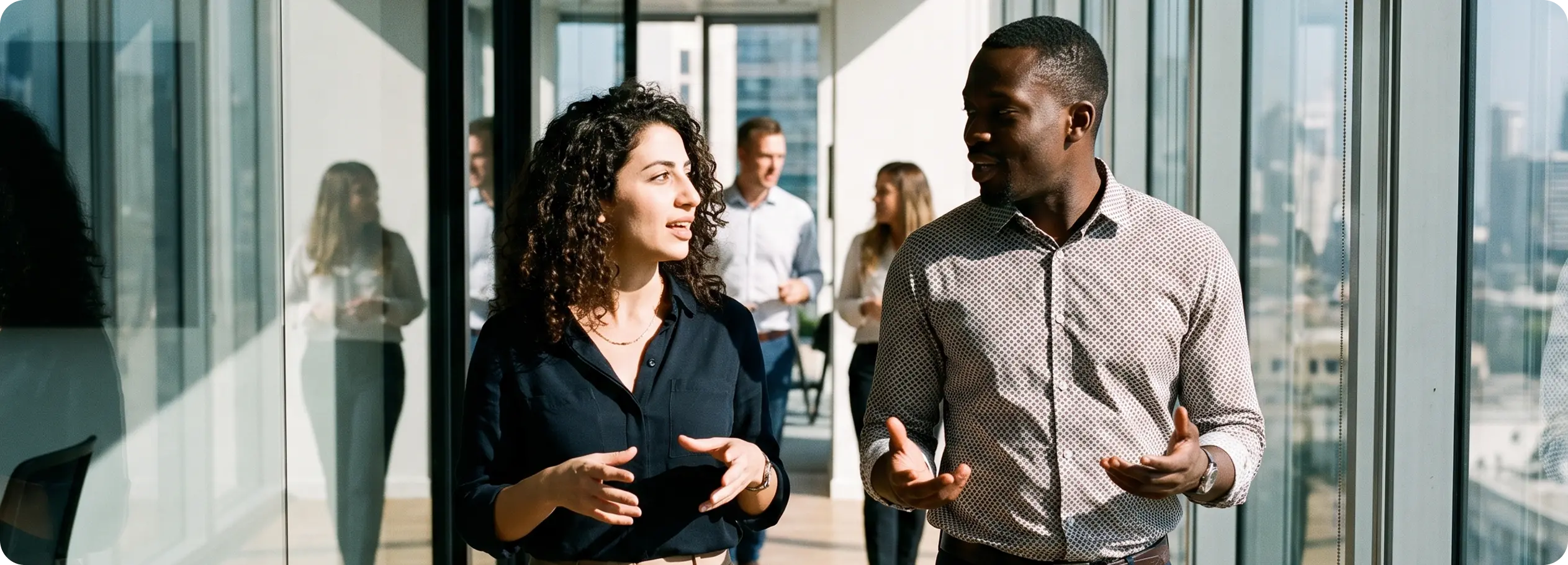 Colleagues talking in a bright office corridor