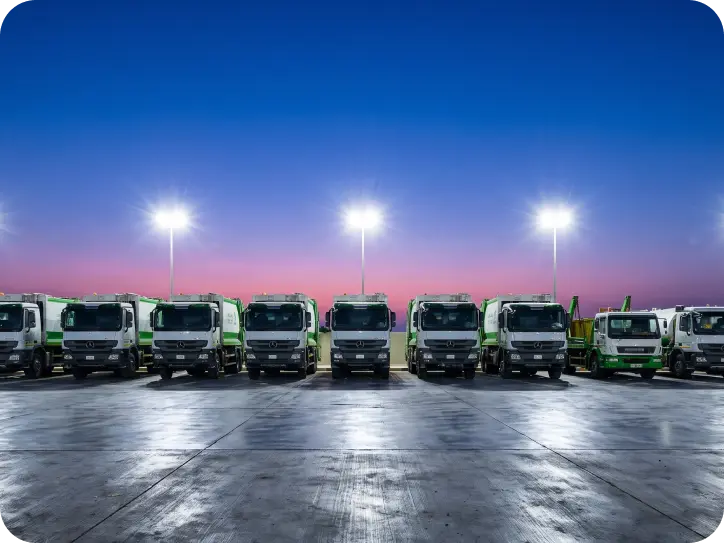 Green Arabia waste collection fleet lined up at dusk