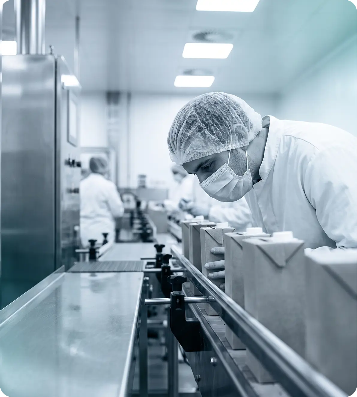 Hygiene-suited operator checking cartons on a packing line