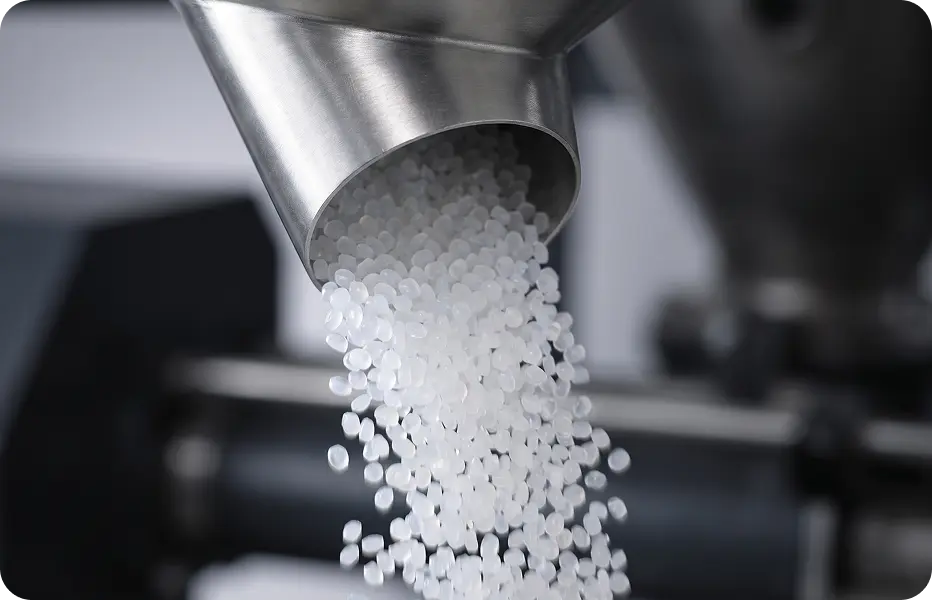 White HDPE pellets pouring from a hopper