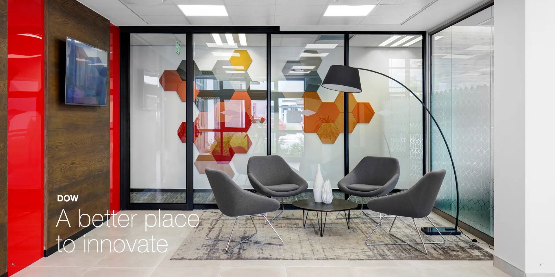 a modern office with a glass walled meeting room