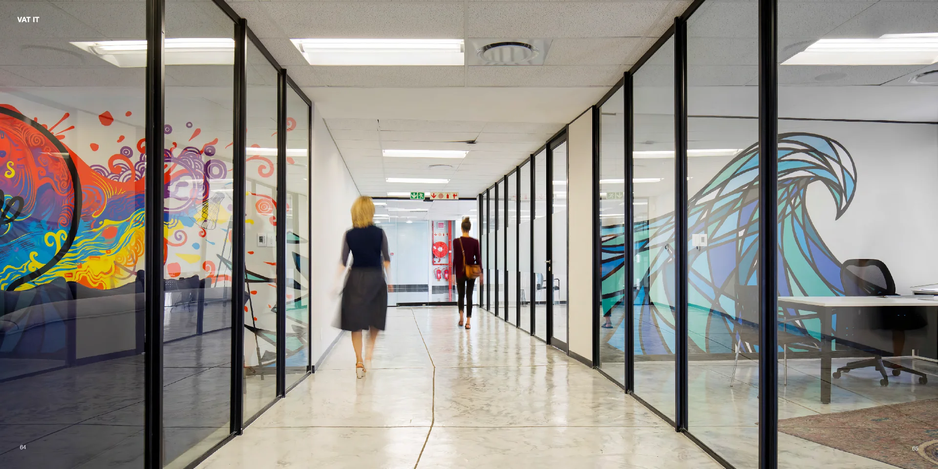 a woman walking down a hallway in an office