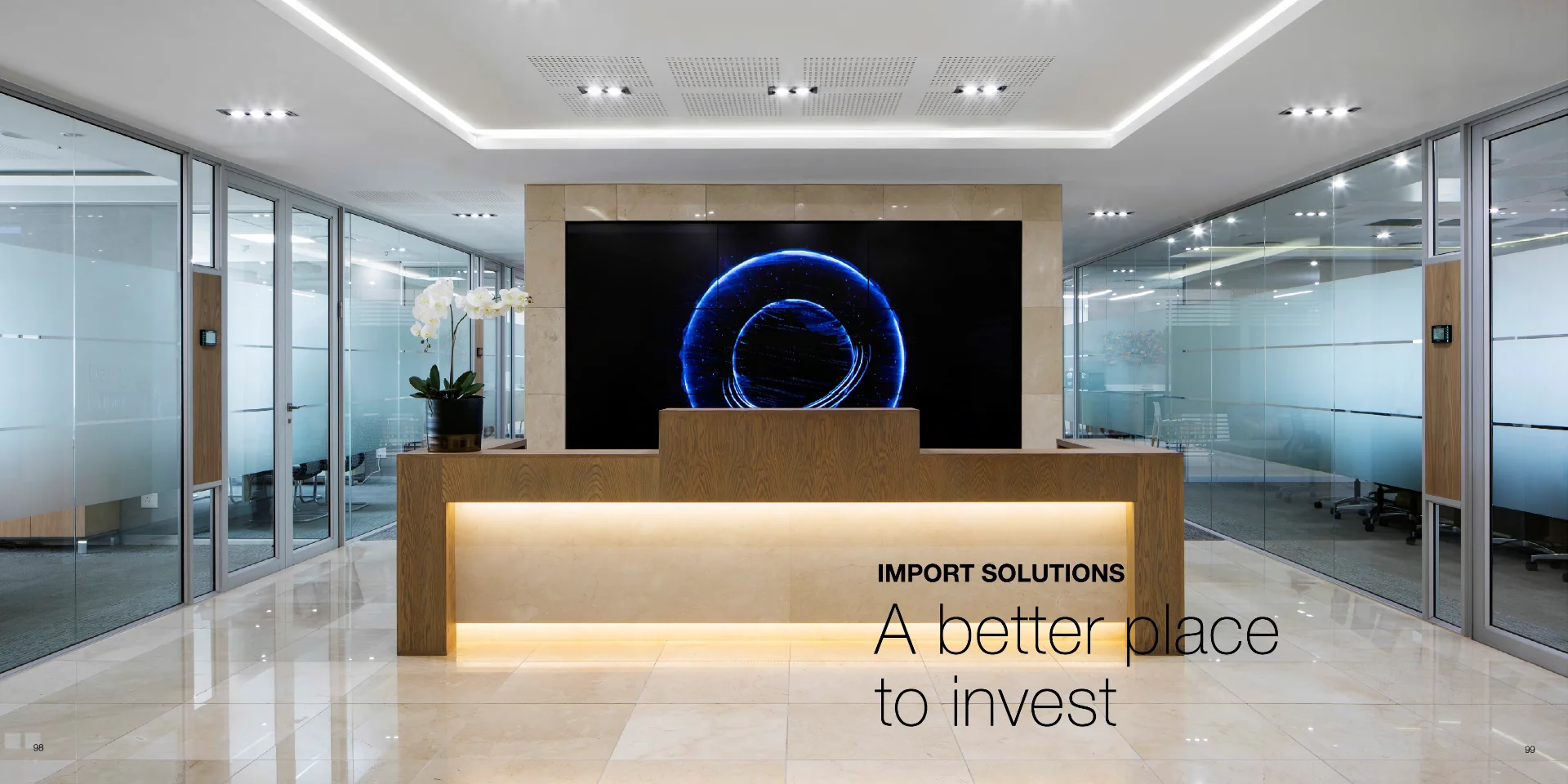 an office lobby with a reception desk and a large screen