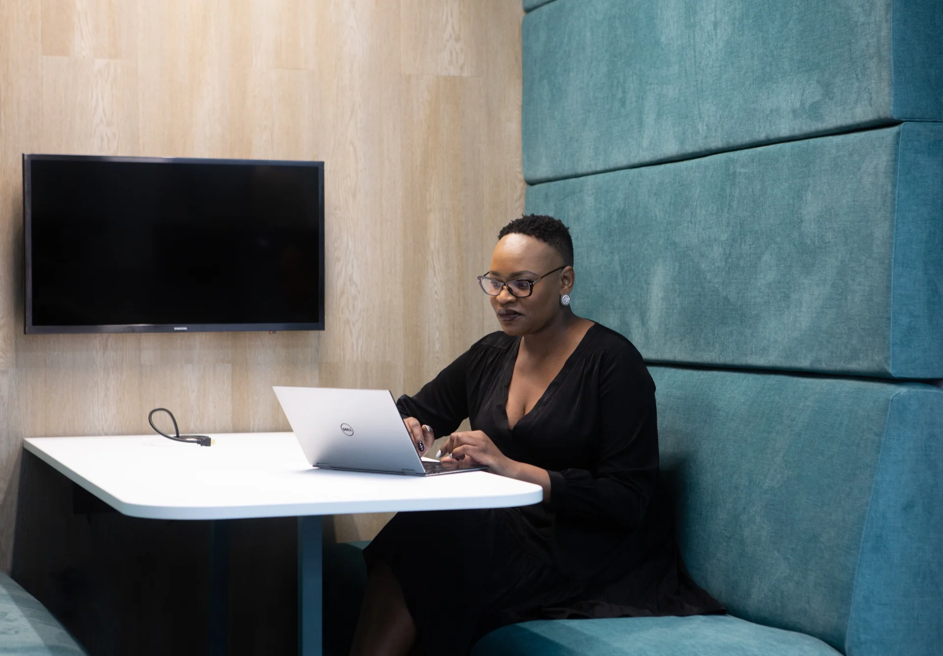 a woman sitting at a table with a laptop