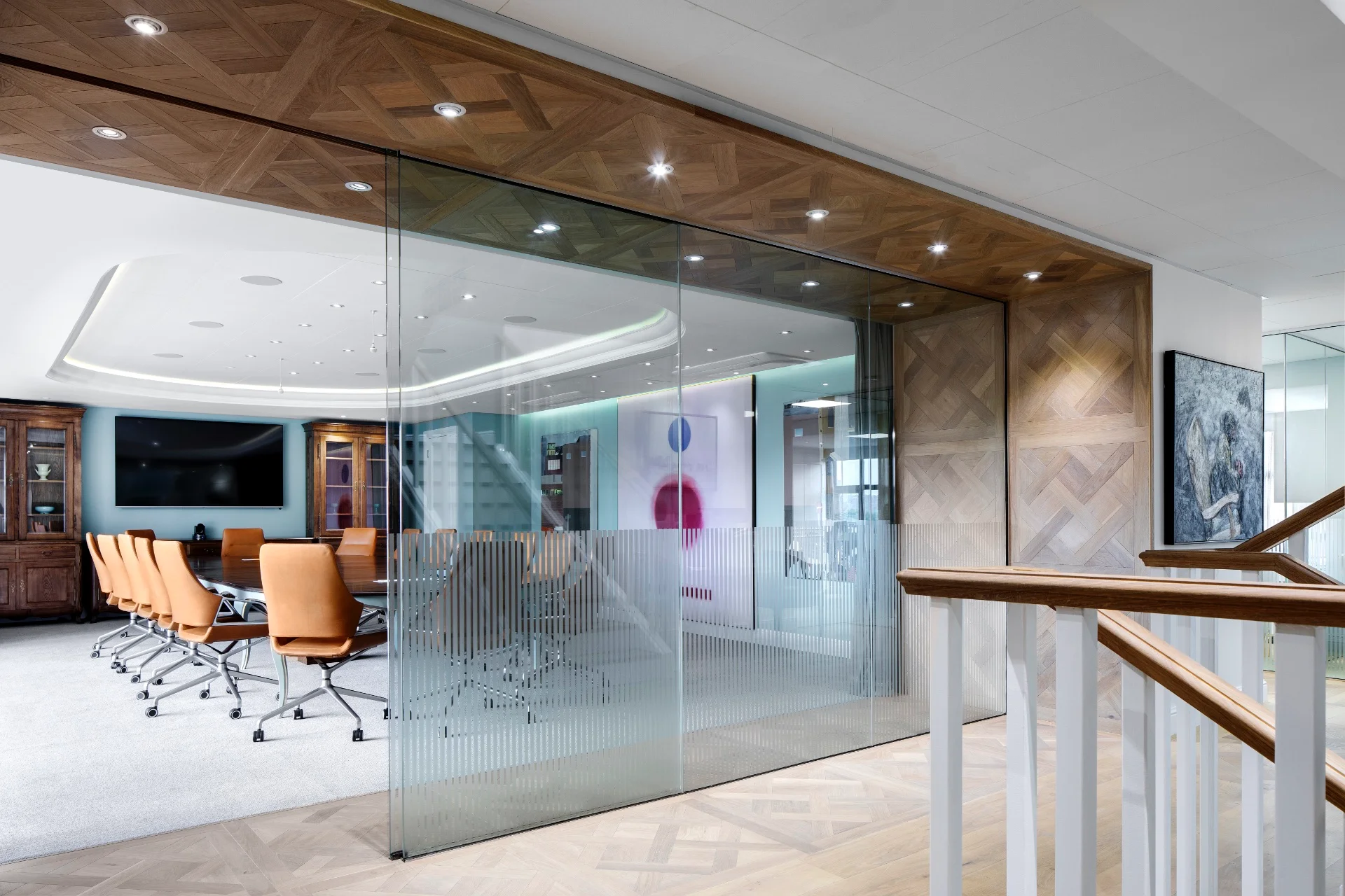 a glass walled meeting room with a television on the wall