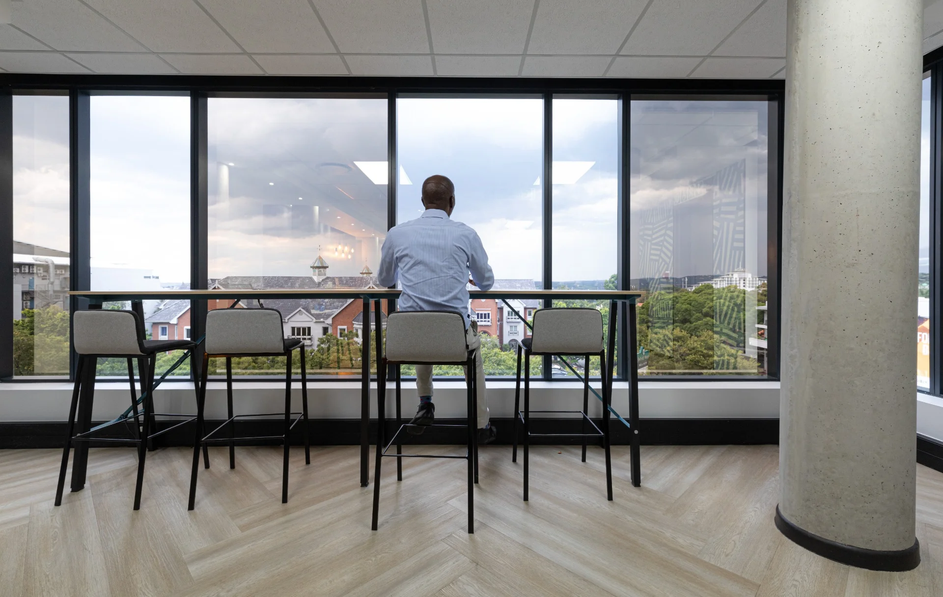 a man sitting at a table looking out a window