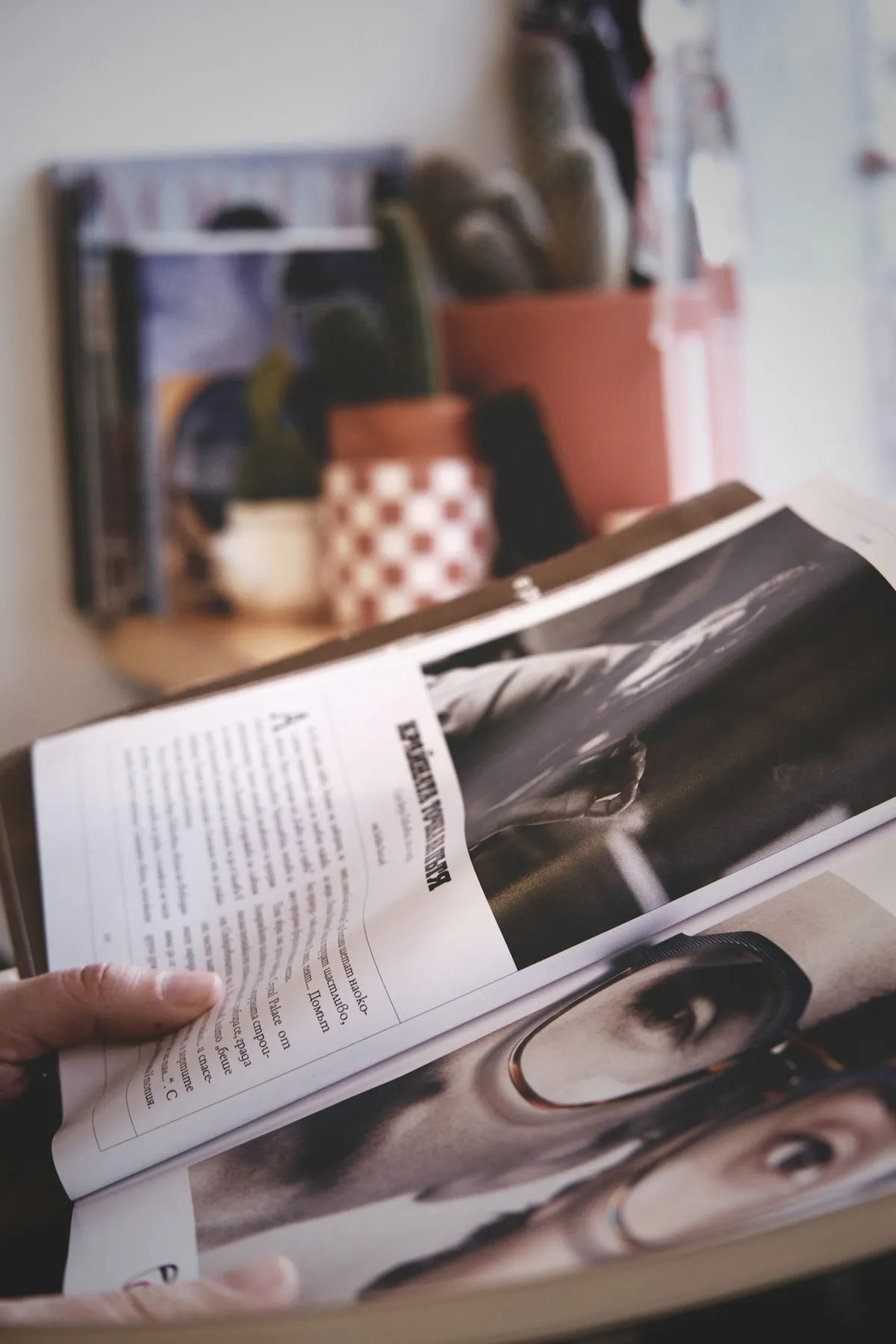 A person reading an open magazine whose photographs are all black and white