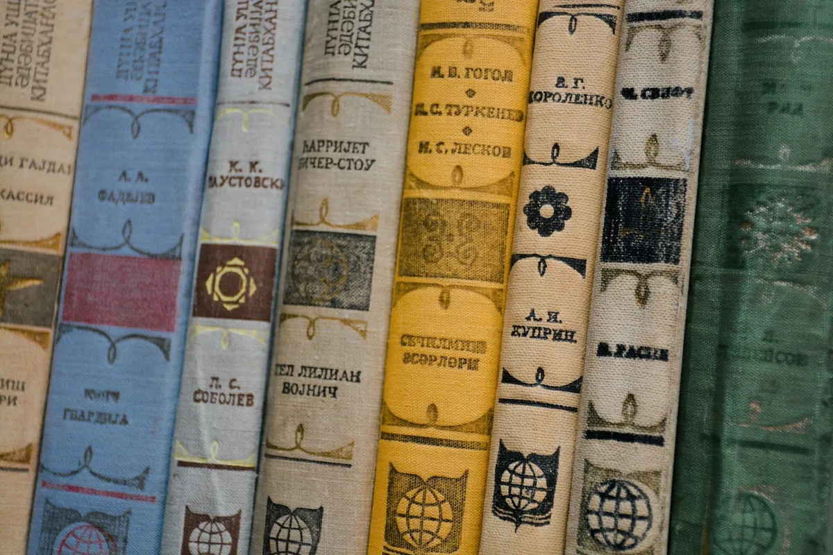 A row of old hardbacks shelved spine outward, each spine carrying its title in stamped lettering