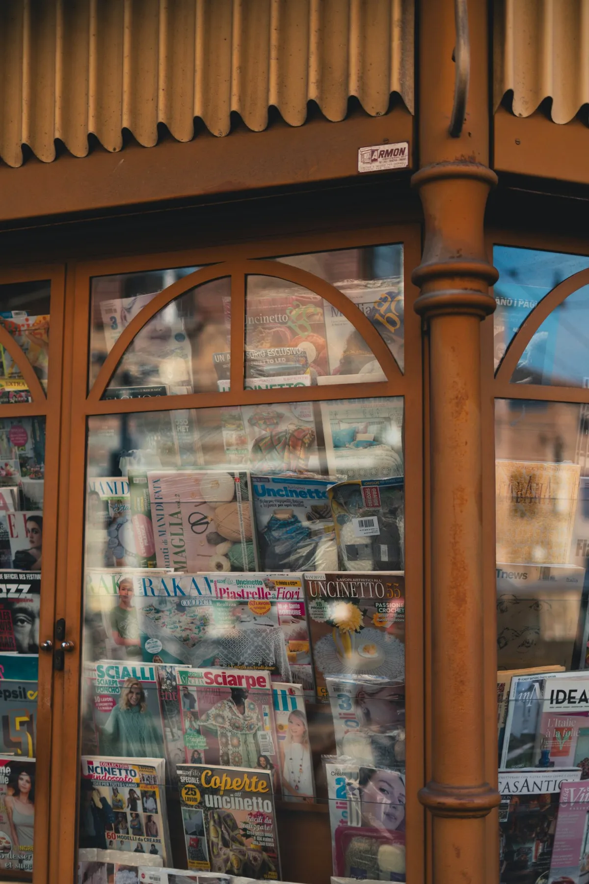 A street newsstand packed with magazines and newspapers, every cover held in the same rectangle