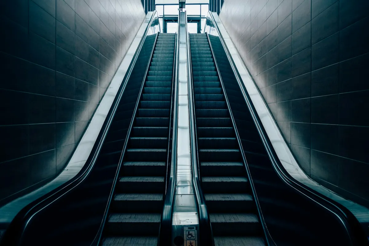 An architectural view of an escalator running between two levels of a building