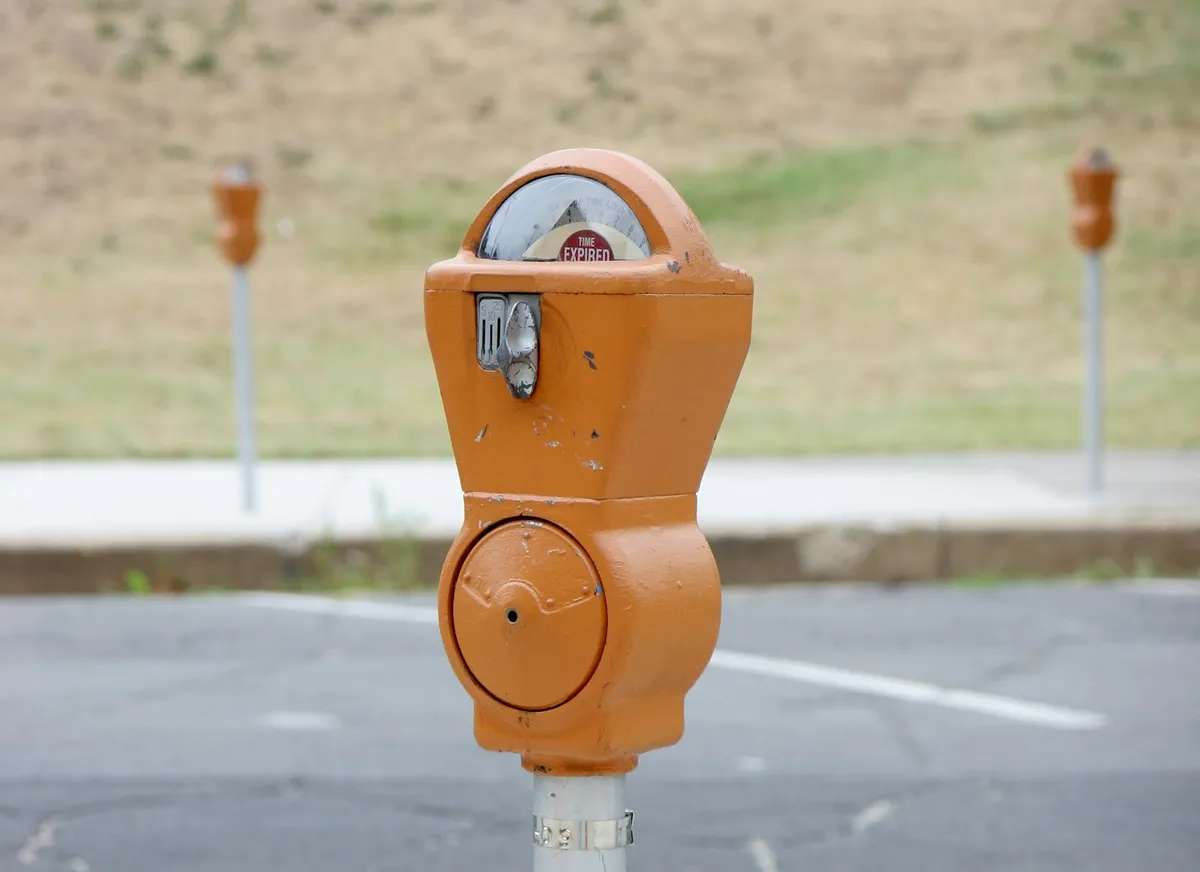 A parking meter standing at the roadside with its display and controls on one face