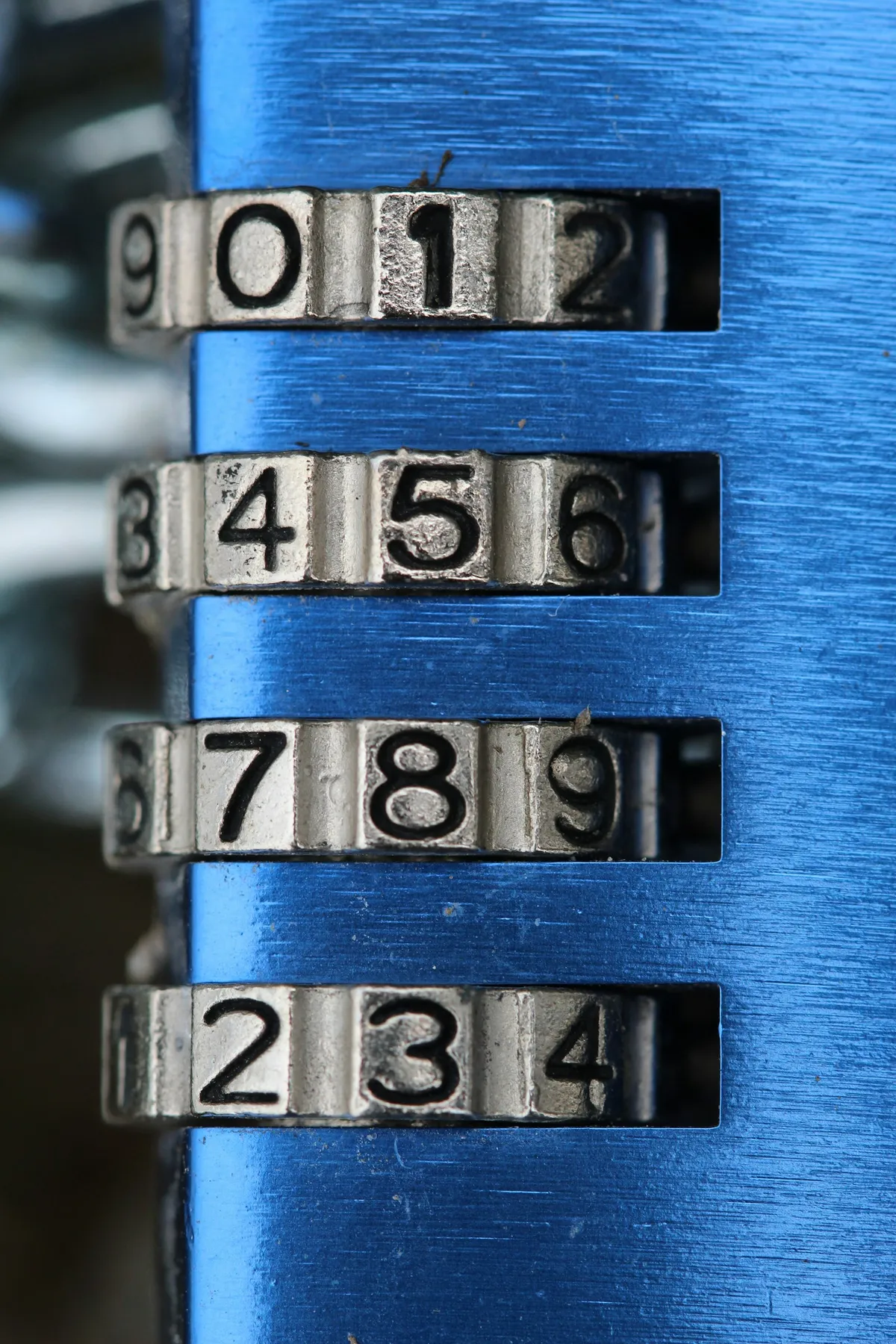 A silver and black combination padlock with its numbered dials showing