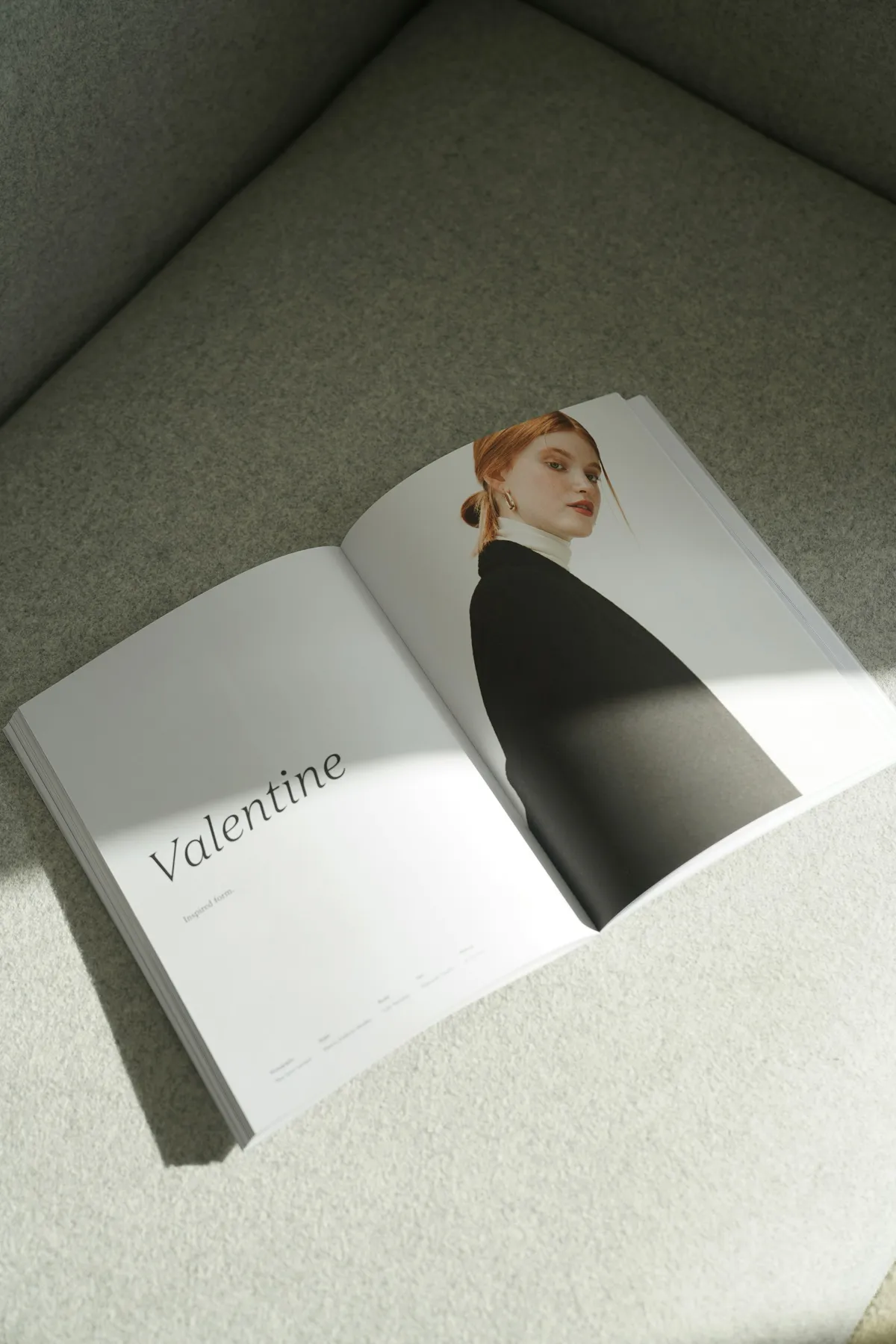 An open magazine spread with a full-page portrait facing a page of quiet text