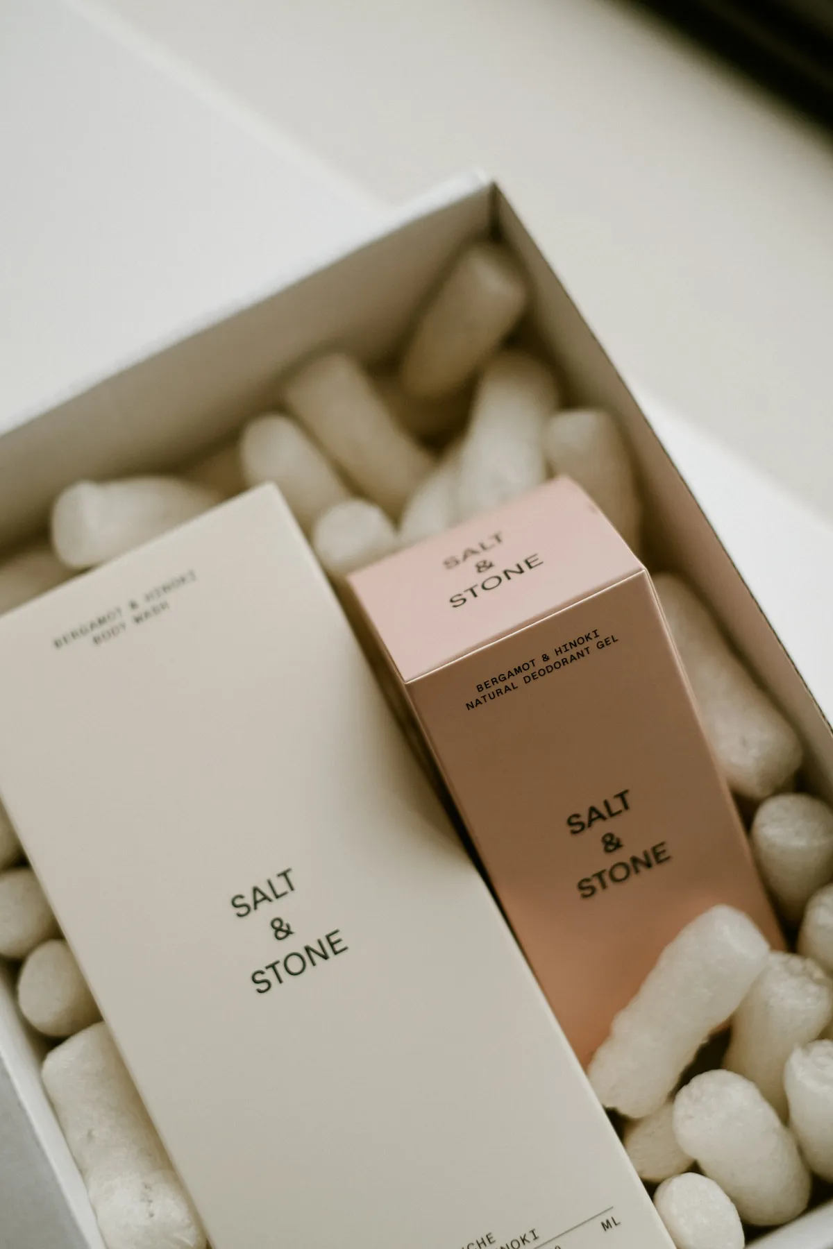 A pale minimal product box with a small centred wordmark on a white surface