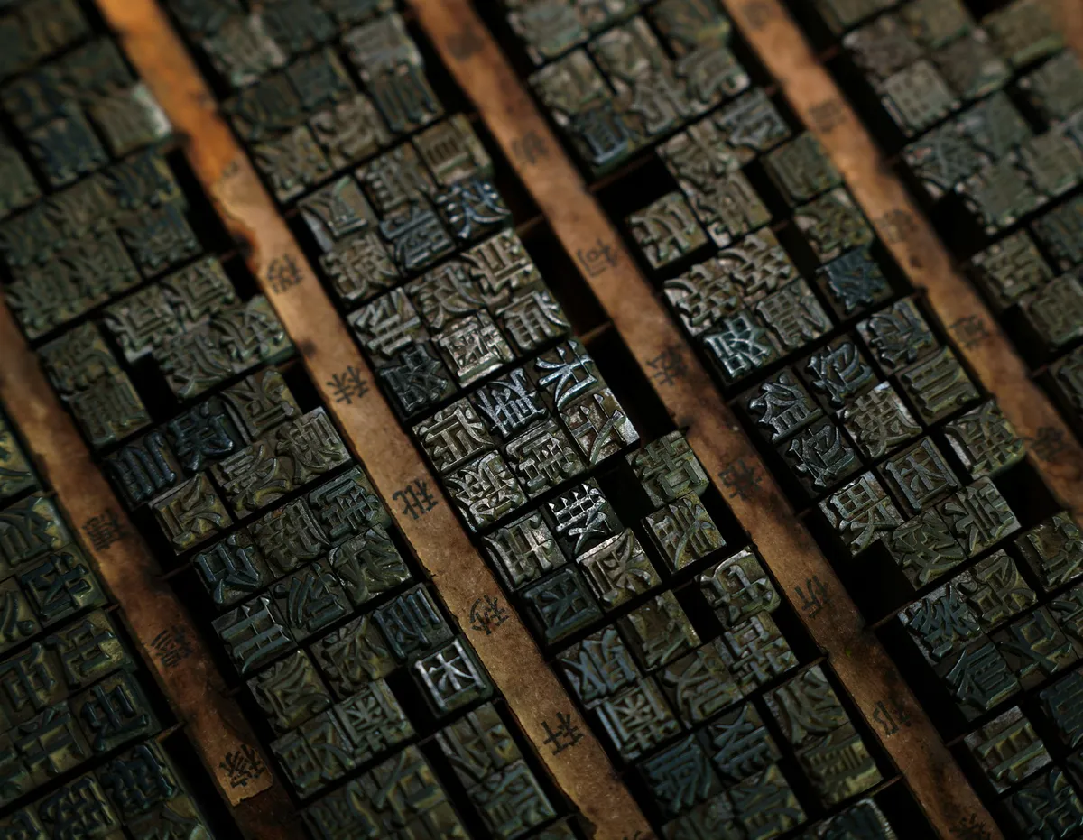 Close view of antique wooden letterpress blocks laid in tight diagonal rows