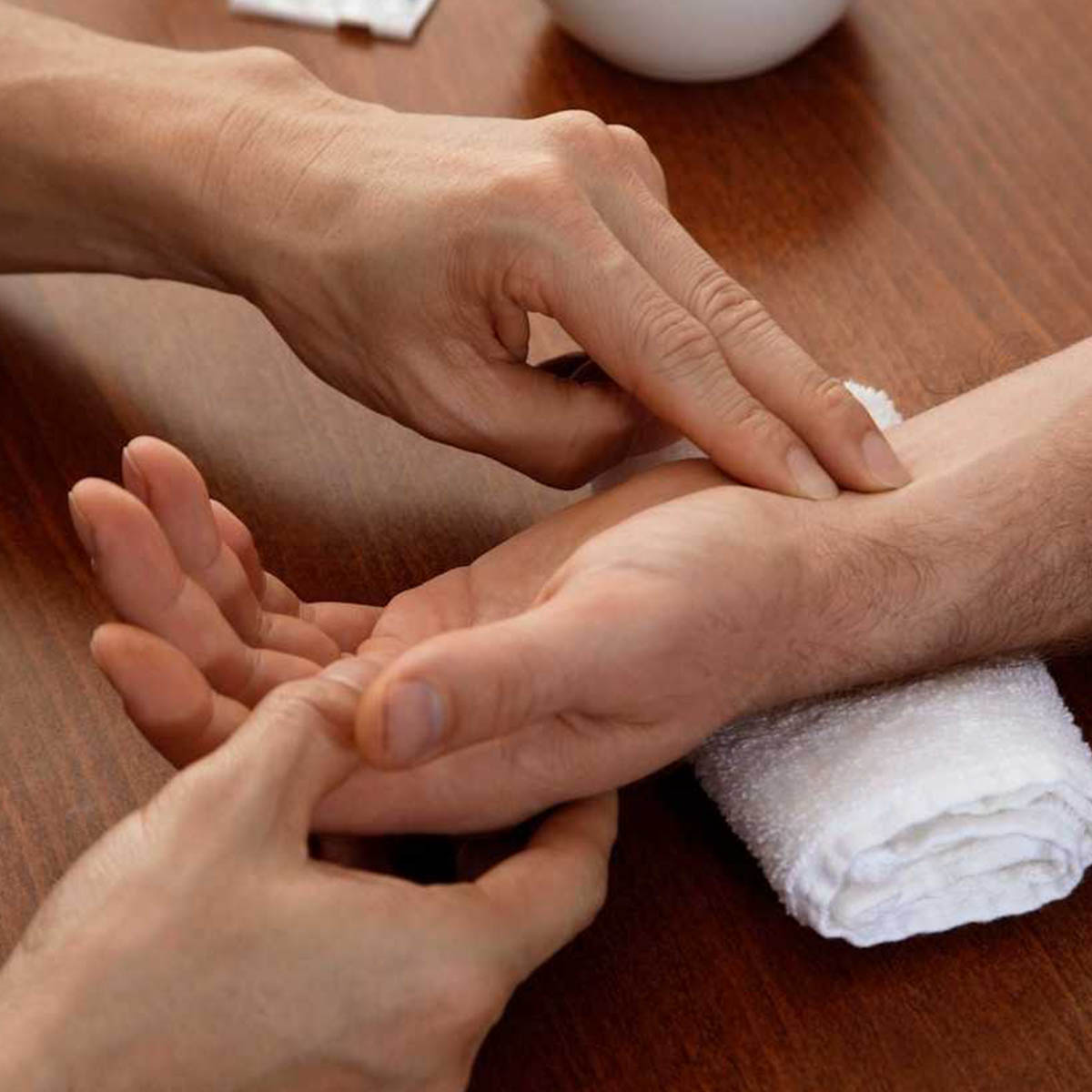 A patient's hand is being held while their pulse is being taken.