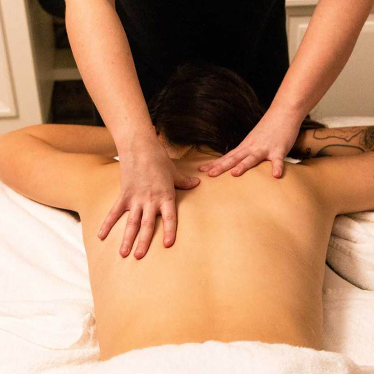 A chiropractor applies treatment to a young woman.